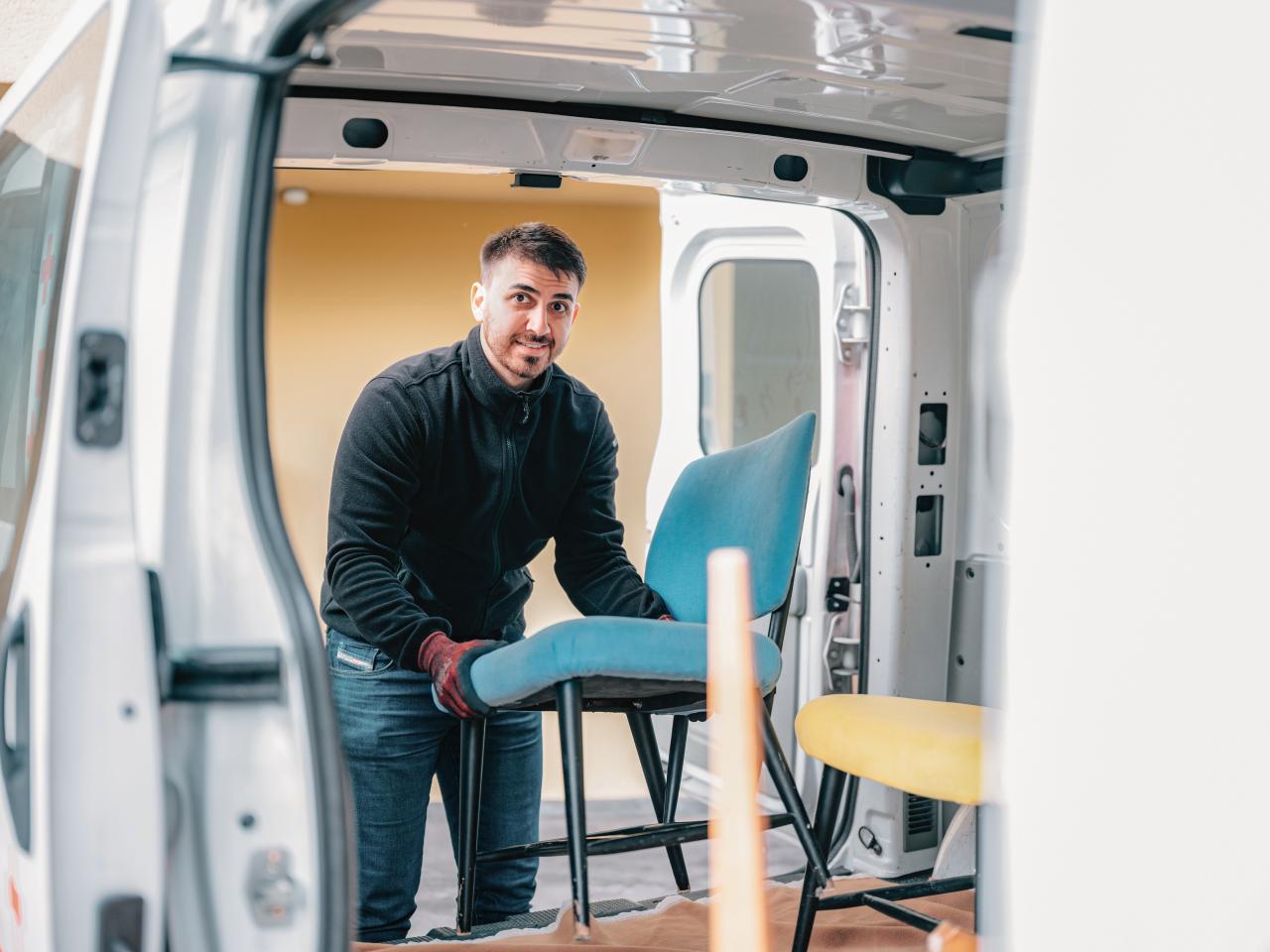 Ein Mitarbeiter von La Trouvaille räumt gespendete Ware in ein Fahrzeug