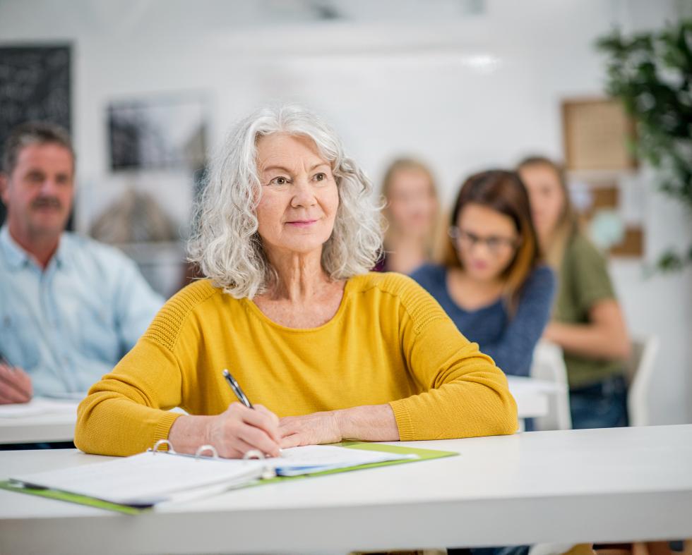 Eine Frau nimmt an einem Kurs teil und macht sich Notizen